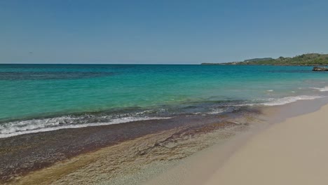 Drone-Volando-A-Baja-Altura-Sobre-Aguas-Claras-Y-Playa-Blanca-De-Playa-Rincón