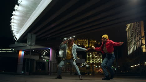 playful couple having fun on street. pair playing funny fight under bridge.