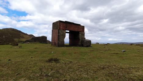 Overcast-clouds-passing-above-rugged-ruins-of-stone-mining-site-on-windy-North-Wales-mountain-valley-summit-time-lapse
