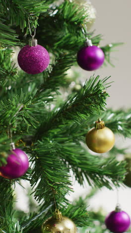 video vertical de primer plano de las bolas del árbol de navidad en el árbol de navidad