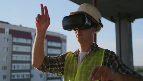 ingeniero: el constructor en el techo del edificio se para en gafas vr y mueve sus manos usando la interfaz del futuro.