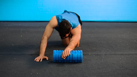 a-hand-held-shot-of-a-guy-using-a-massage-roller-with-only-his-bodyweight