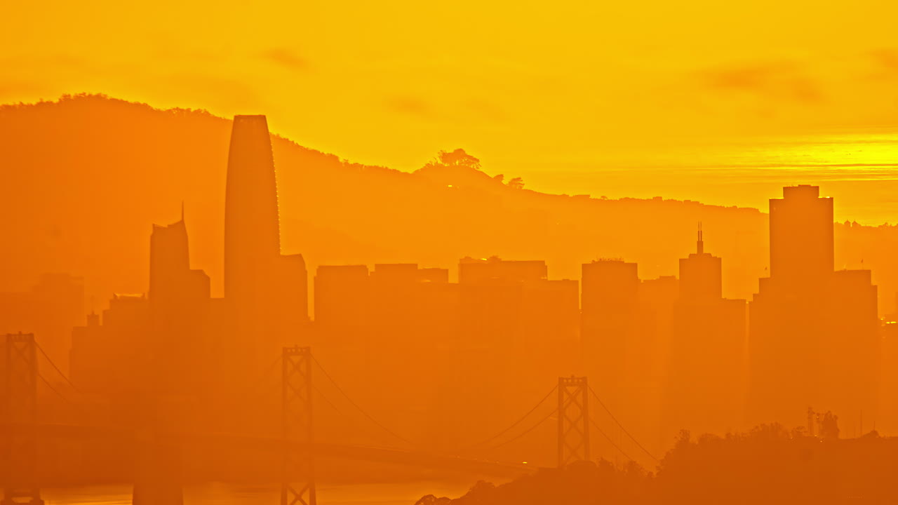 미국 캘리포니아에서 해가 지는 동안 오렌지색 빛으로 가려진 샌프란시스코 스카이라인