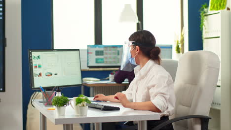 coworkers with protection face masks working in workplace