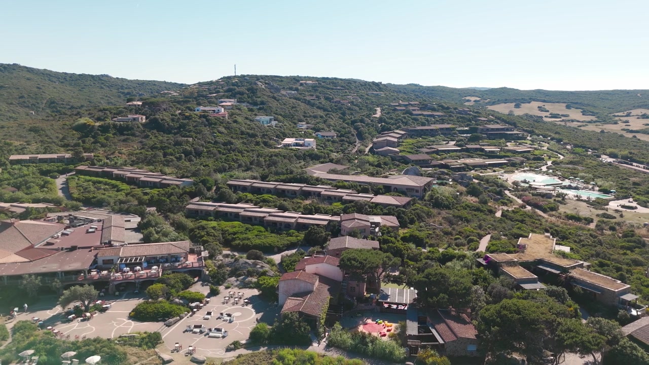 Vista aerea di ville in collina circondate dal verde e da un'area parcheggio in una giornata di sole