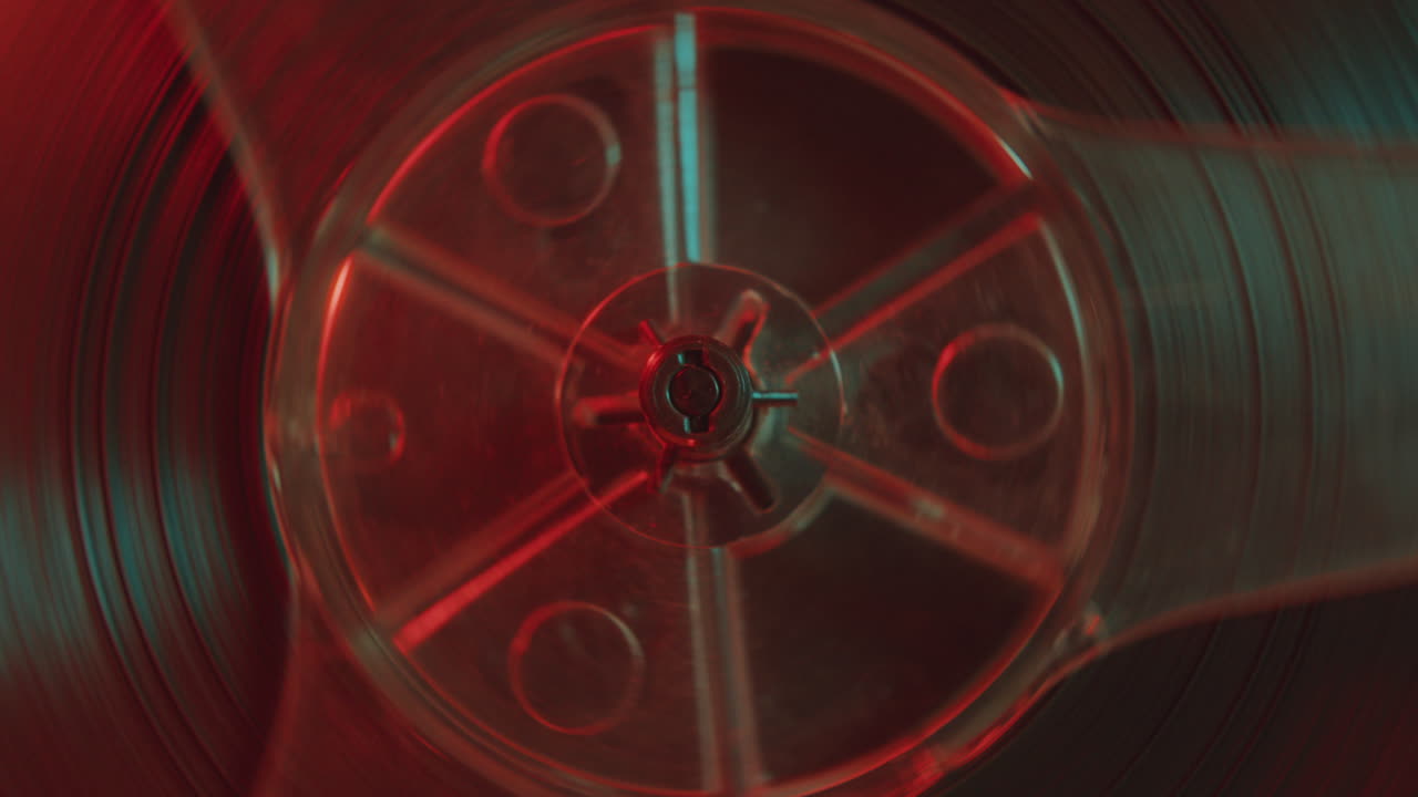 Part of Analog Tape Recorder Reel Rotating in Colorful Neon Light