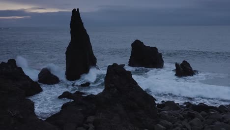 epic shot of dark rock formation and boulders standing on shore of reykjanes,iceland during cloudy mystic day