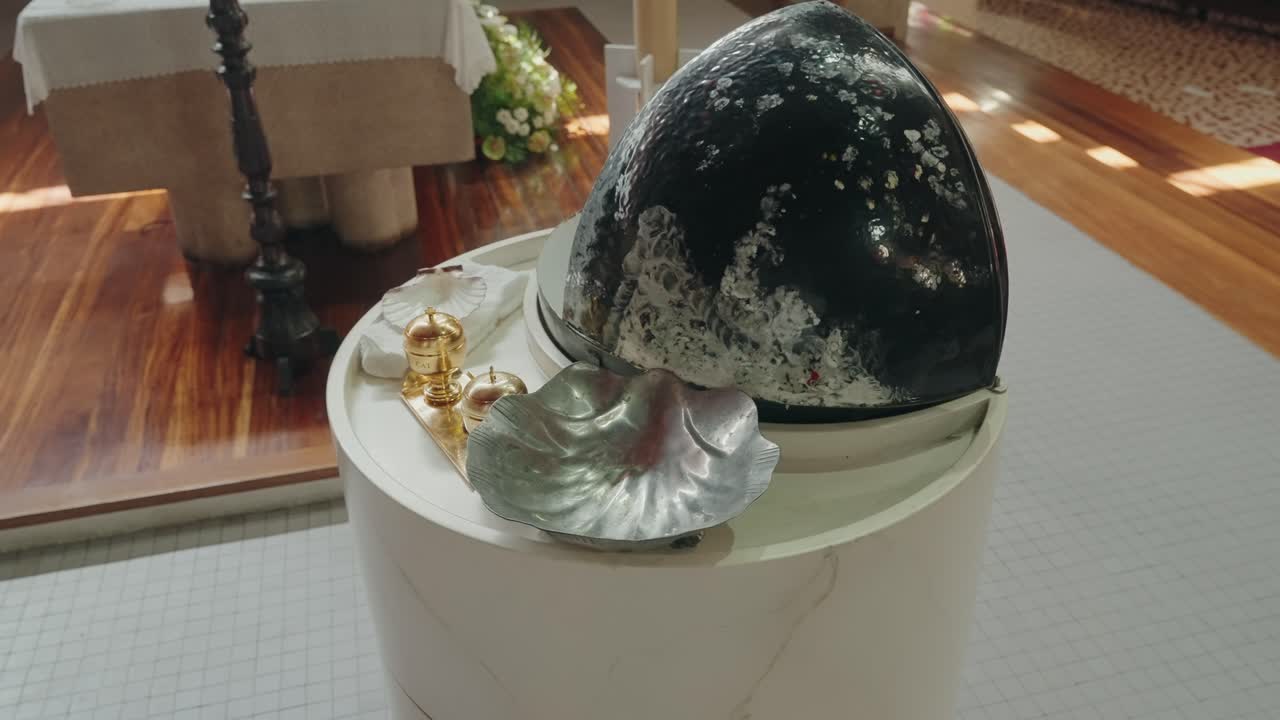 Close up of baptismal font and silver shell used for holy water ritual in church