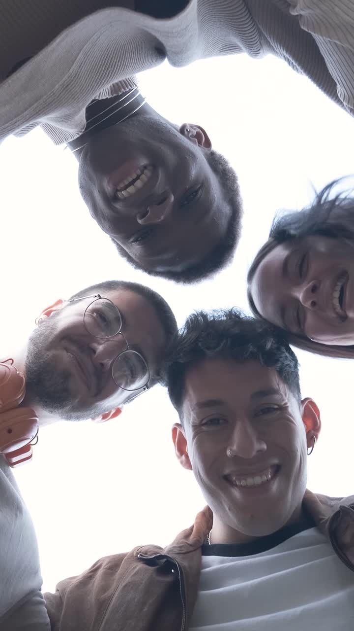 Group of students of different ethnicities hugging each other in a circle