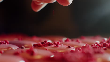 hand decorating macarons with raspberry
