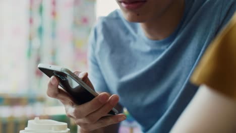 Handheld-view-of-man-with-mobile-phone-at-cafe