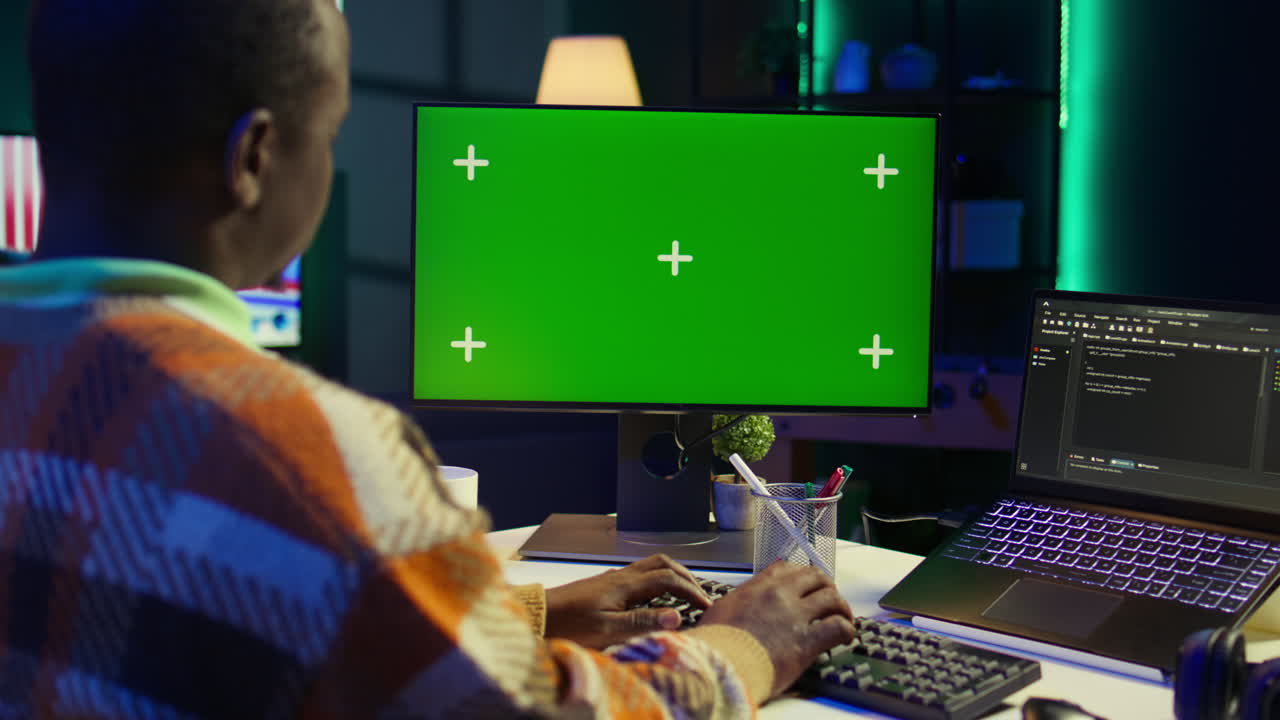 Person working on computer with green screen