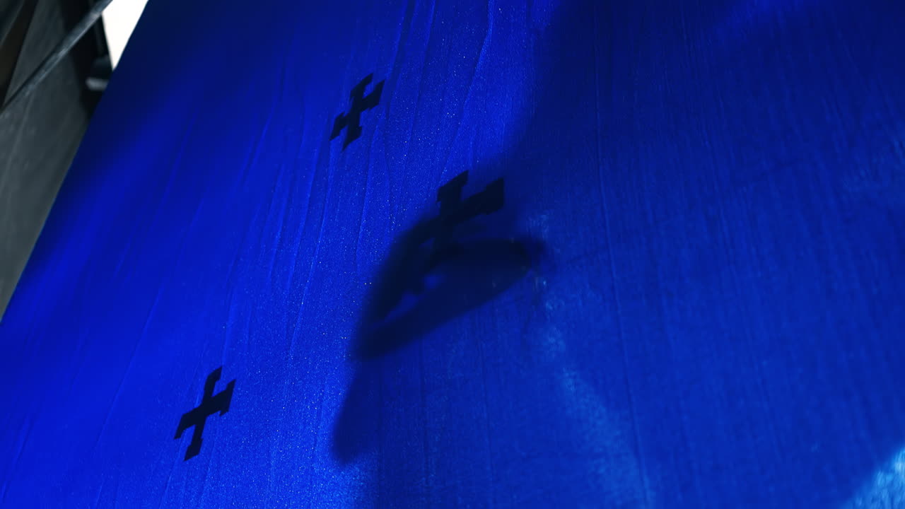 Red tracking markers on a chromakey with a man's shadow in a pose on it, movie set