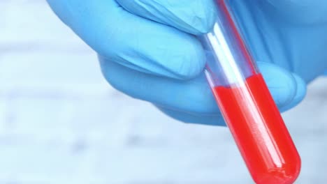 scientist holding a test tube with red liquid