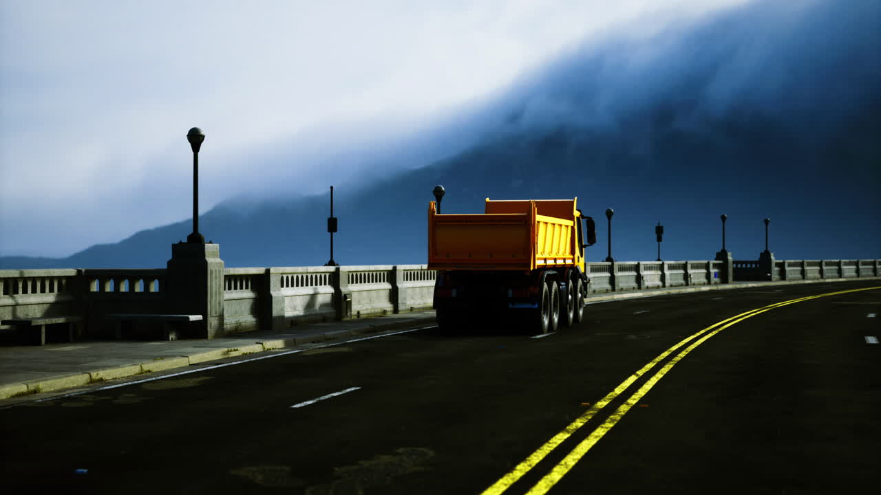 Orange dump truck navigating a winding road beside a scenic overlook