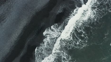 rising from mythical dark sand beach on iceland south shore, aerial