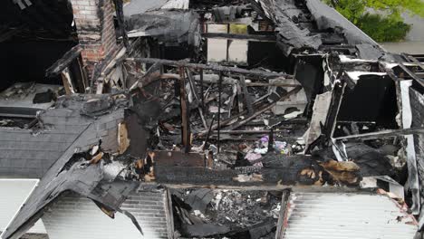 Devastated-feel-of-seeing-burnt-down-family-home,-close-up-aerial-view