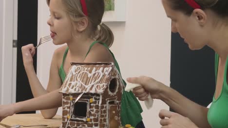 family decorating a gingerbread house