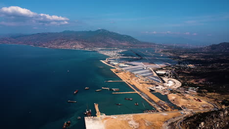 Aerial-descending-over-Ca-Na-General-Port-construction-sites,-Vietnam