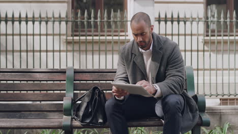 handsome businessman browsing a tablet outside