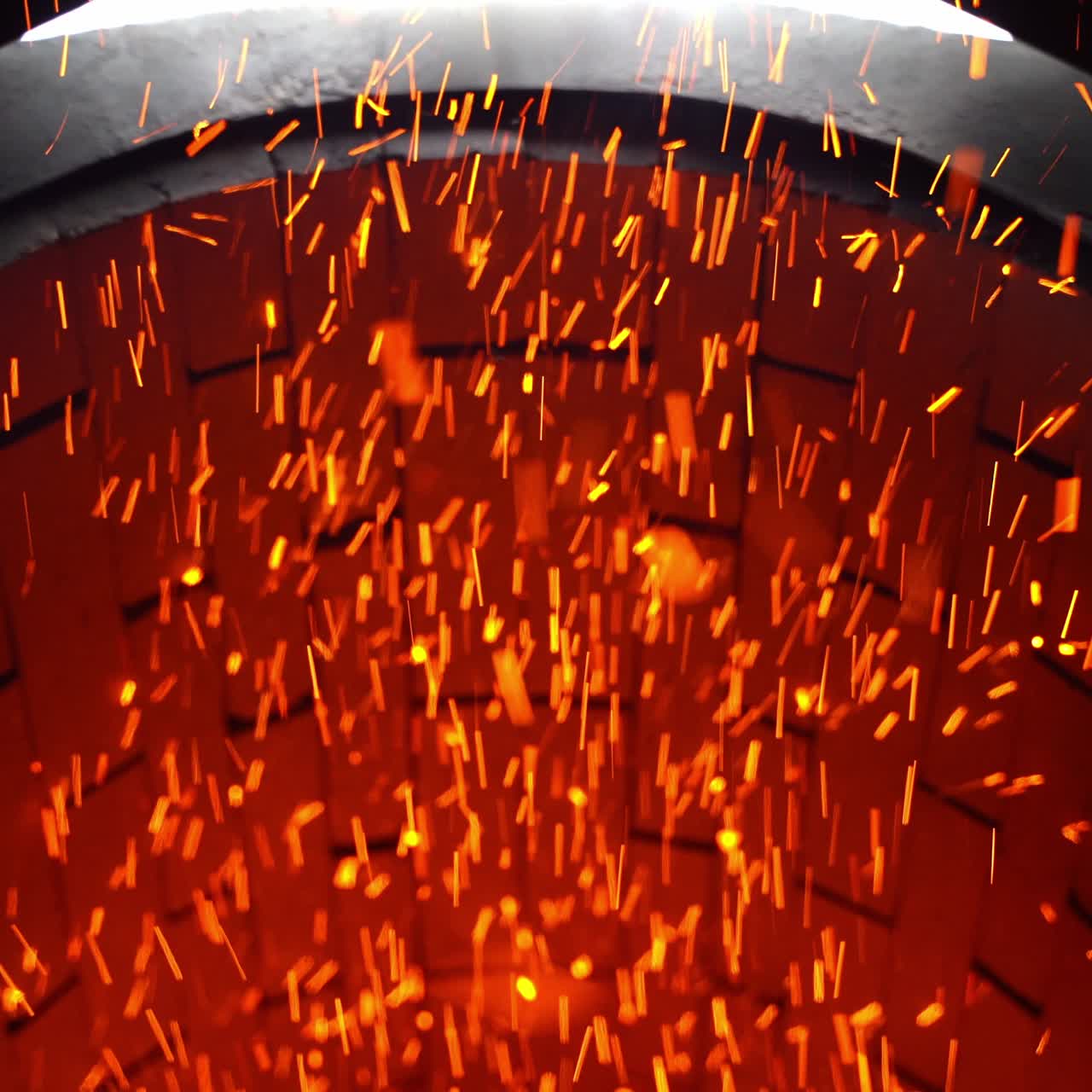 Fast shining sparkles flying quickly from their source. Bright ablaze particles at the brick backdrop. Close up