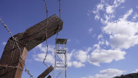 a prison guard tower against a cloudy blue sky