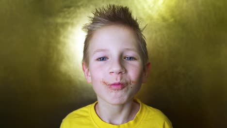 niño feliz comiendo una rosquilla de chocolate. niño comiendo comida chatarra. rubio disfruta de dulces.