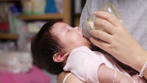 mother bottle feeding her baby