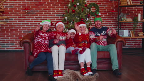familia riendo saludando con las manos hola, hola, saludando mientras se toma un selfie en un teléfono inteligente en casa de navidad