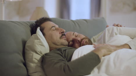 una hermosa pareja homosexual durmiendo en la cama y abrazándose.