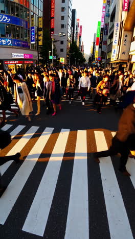 crowd of pedestrians crossing a street in a busy japanese city