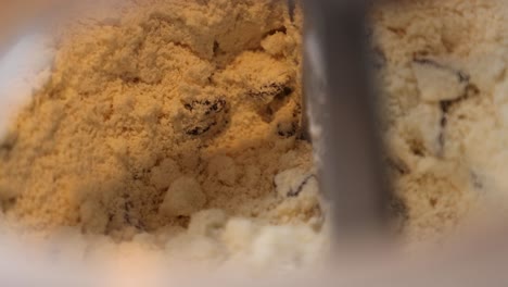disparo en primer plano de una mezcla de bollos mezclada en un mezclador industrial en una panadería