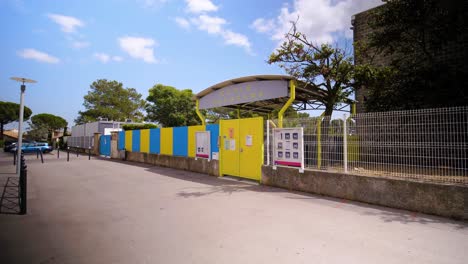 Closed-gate-at-the-entrance-of-Ecole-Kurosava-in-Montpellier,-with-a-fence-and-no-people-on-the-street