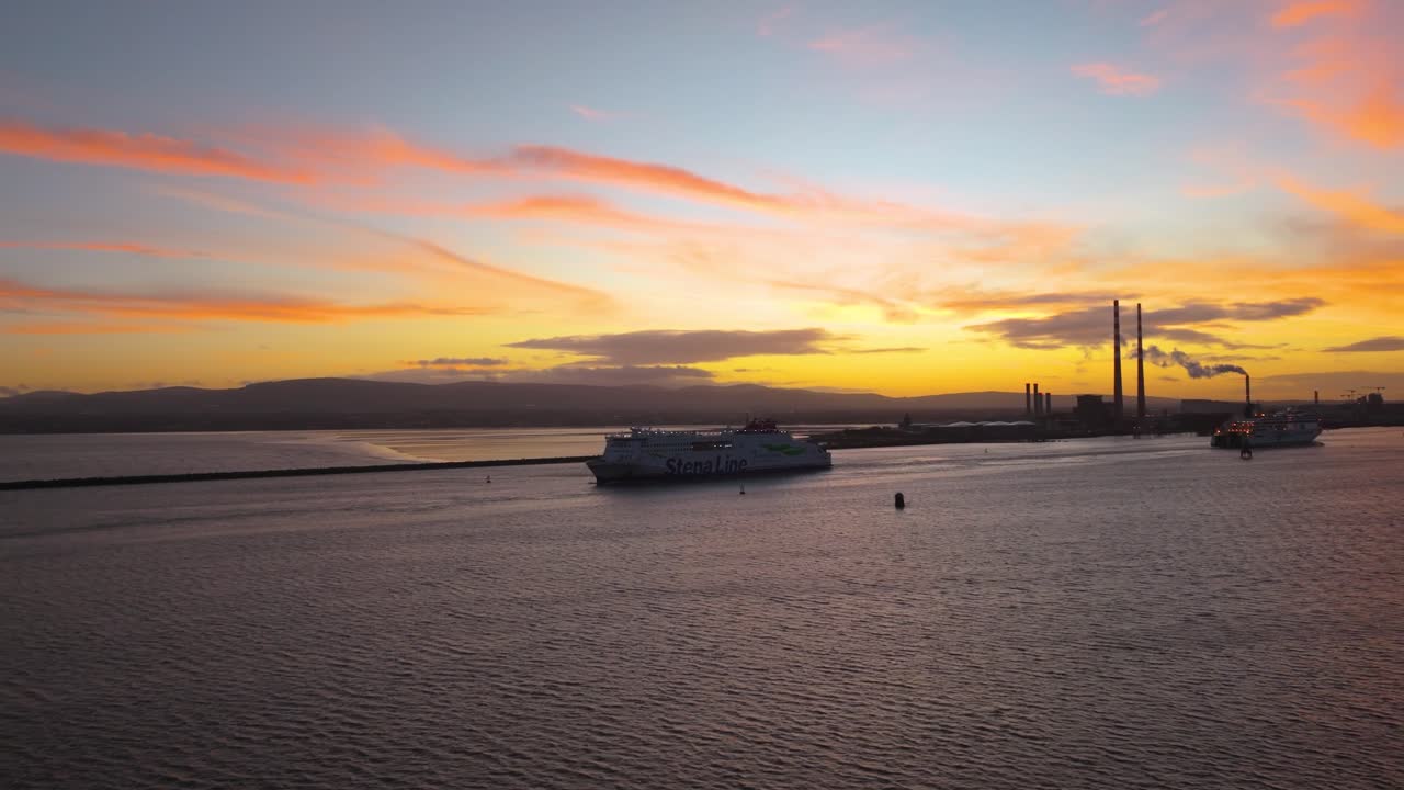 Filmagem cinematográfica com drone em 4K mostrando as Chaminés Poolbeg em Dublin durante um pôr do sol de tirar o fôlego na hora dourada, enquanto um ferry atravessa a cena em luz dramática_42