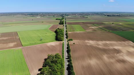 a long road connecting two towns in hungary, europe, drone shot
