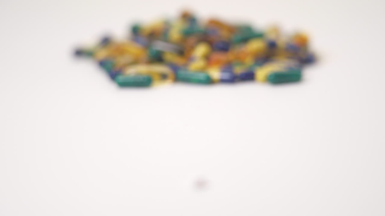 foco de rack macro de una píldora a un montón de píldoras sobre fondo blanco