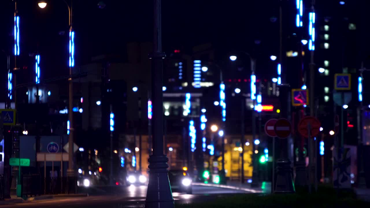 Nächtliche Stadtstraßenszene mit blauen Lichtinstallationen