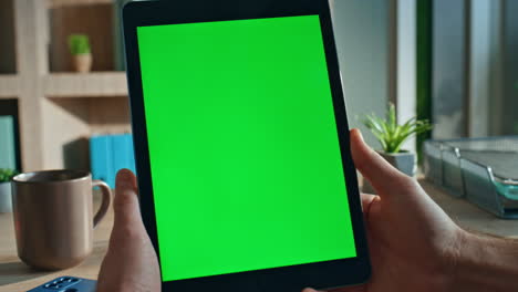 employee surfing online chroma key tablet in company office close up. man hands