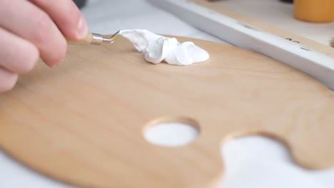 artist mixing watercolor paint on palette, close up