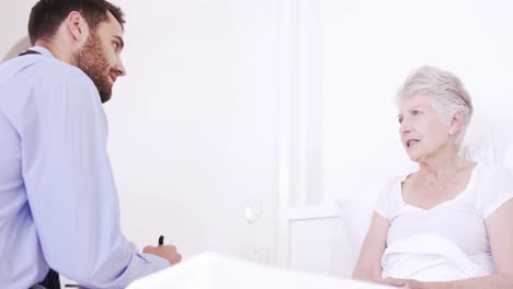 Male-nurse-talking-with-senior-couple