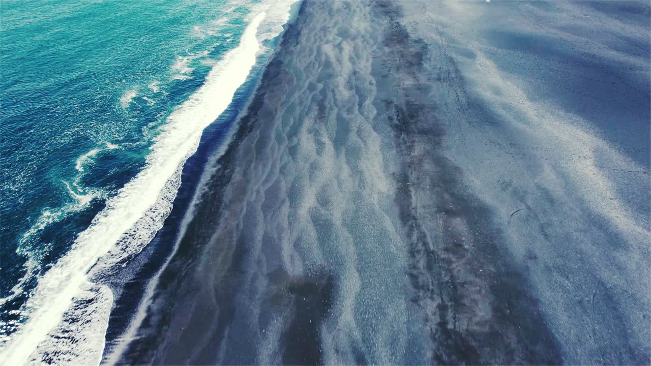 drone volando sobre una gran playa negra con la cámara inclinándose lentamente sobre la costa en islandia 4k