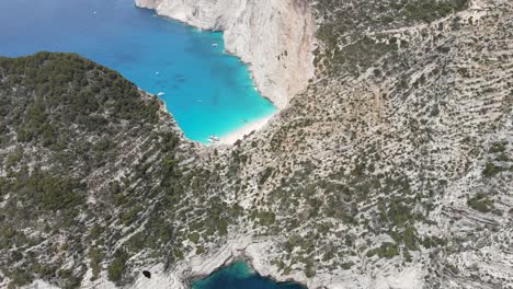 Aerial-view-of-a-paradisiac-beach-with-turquoise-water-and-a-shipwreck-ship-on-the-coast-of-Zakynthos,-in-the-Ionian-Islands-of-Greece