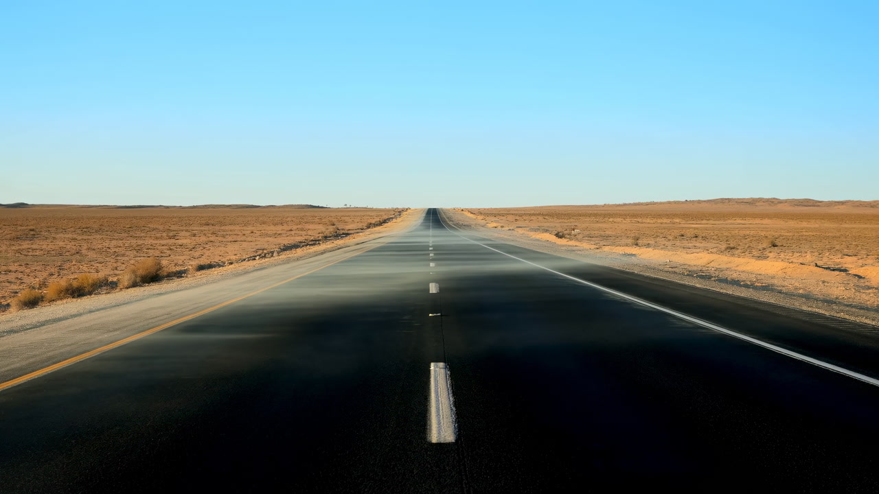 Endless Desert Highway Stretching Into Distance, Sunlit Asphalt Center Stripe Leading Toward Flat Barren