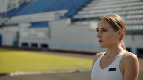 movimiento lento: mujer atleta espera el comienzo de la carrera en 400 metros. chica atleta espera el inicio de la raza en 100 metros durante. corriendo en el estadio desde las almohadillas en la cinta de correr