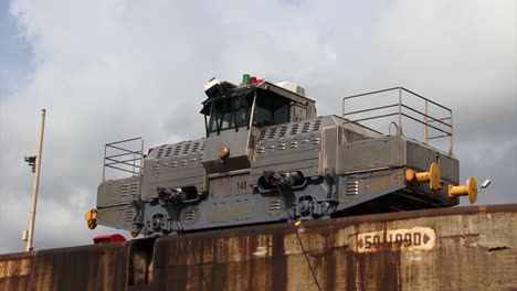 Panama-canal,-Gatun-locks,-locomotive-slowly-pulling-the-ship-in-the-chamber