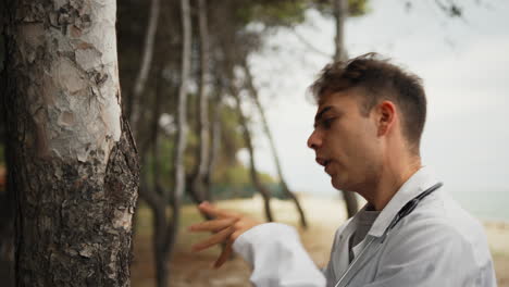 technician talks to the trunk of a tree like a crazy person in the park