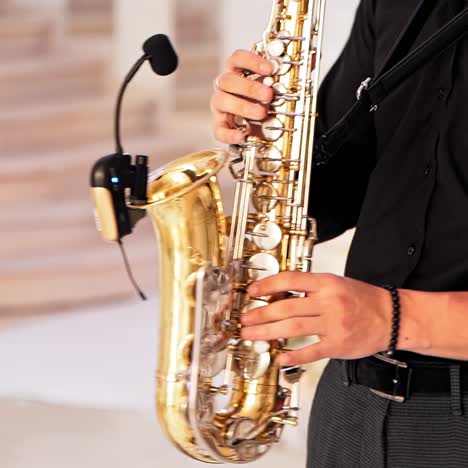 man play on axophone with microphone