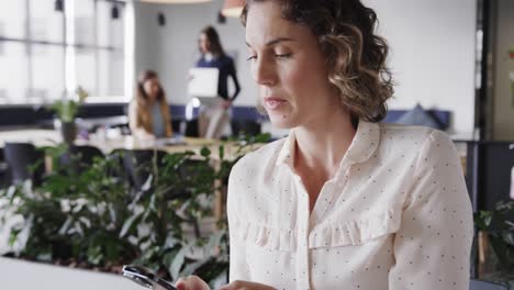 Caucasian-casual-businesswoman-talking-on-smartphone-in-office,-slow-motion