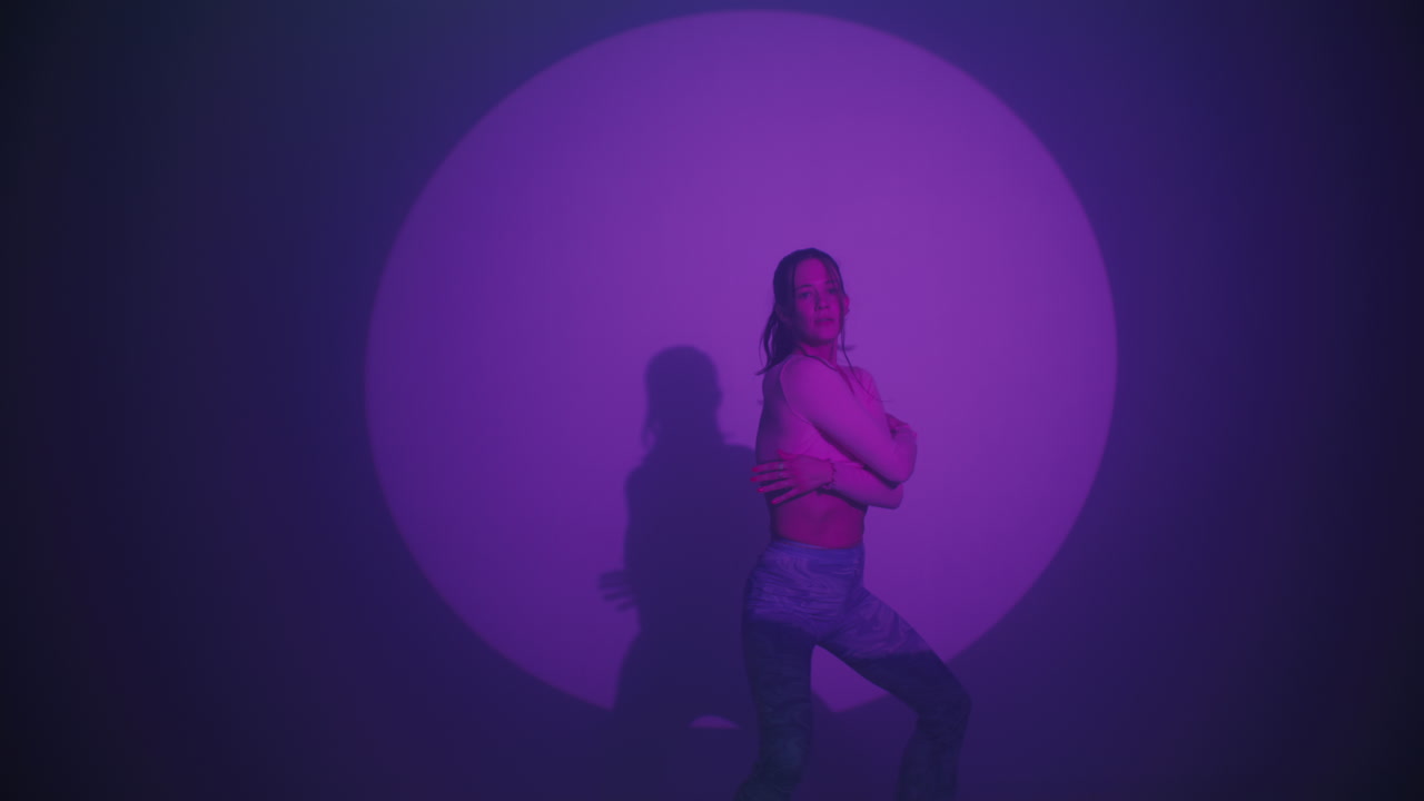 Woman Dancing in a Purple Lit Studio