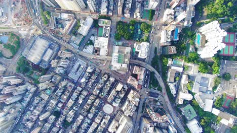 traffic passing through a car park building in downtown hong kong, with city mega buildings, aerial view